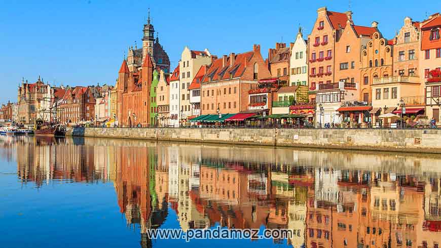 عکس شهر قدیمی گدانسک در لهستان با ساختمان هایی بسیار زیبا و رنگارنگ کنار رودخانه ایی آرام و زلال. در تصویر عکس ساختمانها به زیبایی در آب دیده می شوند