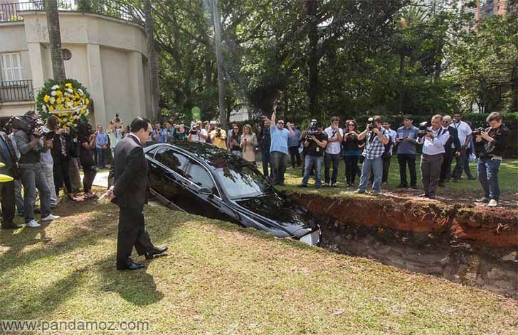 عکس دفن کردن نمادین ماشین گرانقیمت آقای بنت لی ثروتمند برزیلی برای اهمیت دادن به اهدای عضو. در تصویر گودالی در یک پارک کنده شده و ماشین او در حال ورود به گودال است.  فیلمبرداری نیز در تصویر دیده می شود