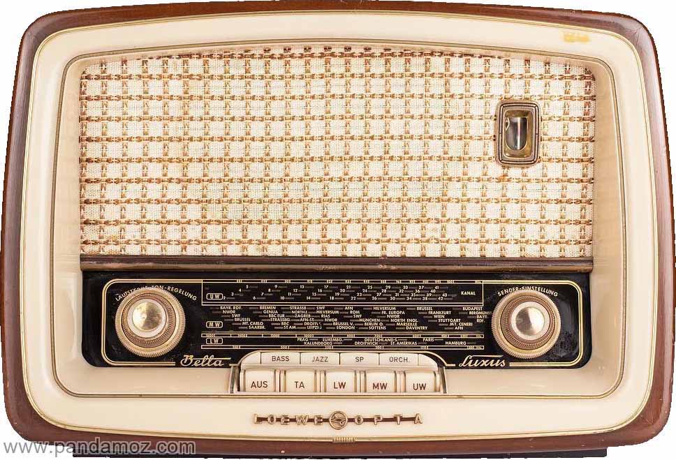 عکس بزرگ رنگی از رادیو لامپی قدیمی و عتیقه. در تصویر یک رادیو لامپی با کلیدهای موج بلند و کوتاه و به رنگ قهوه ایی با بدنه چوبی و پارچه توری جلو دیده می شود